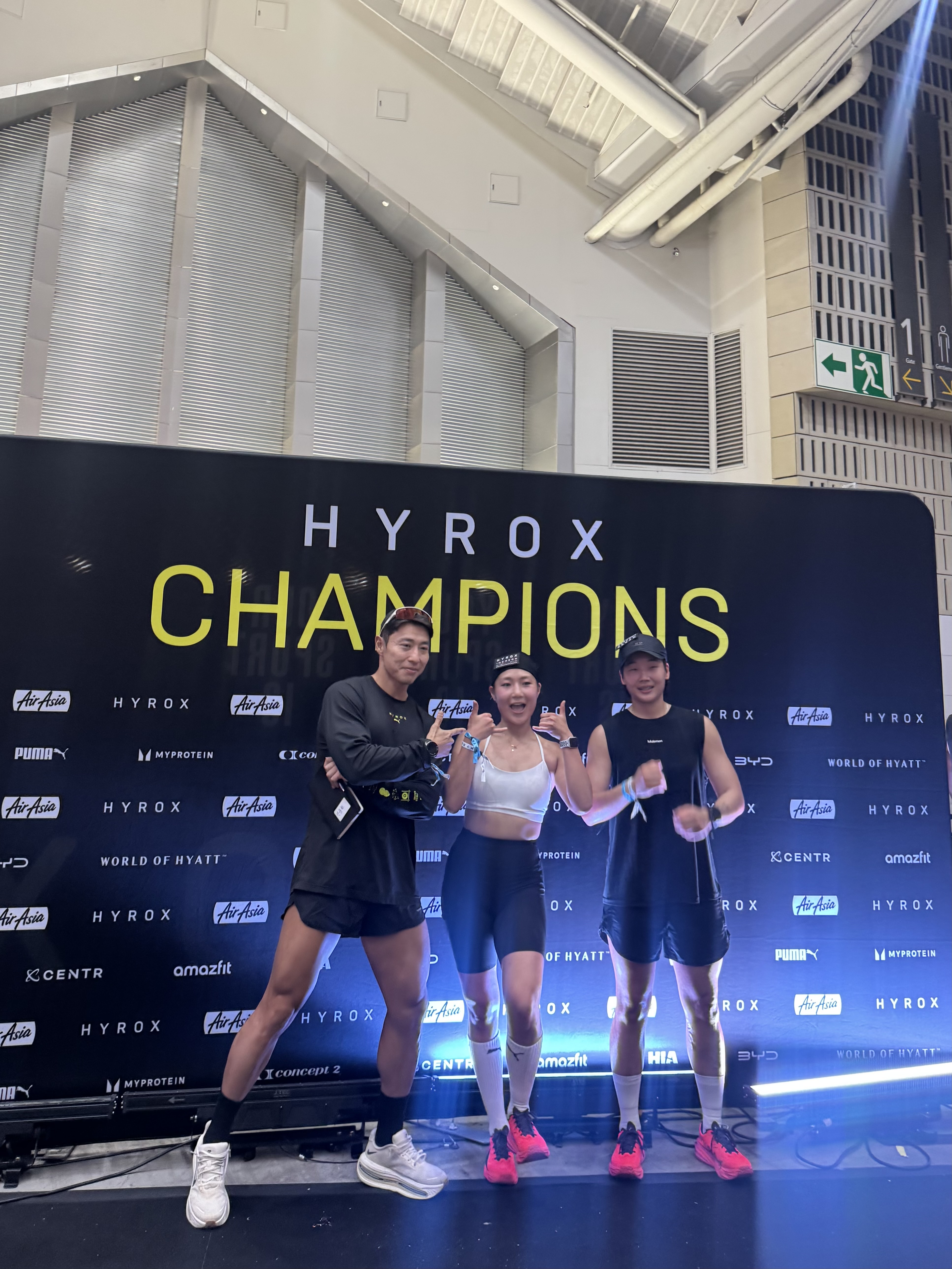 HYROX 챔피언스 포토월 앞에 선 임유빈, 이규리 선수와 전준현 코치